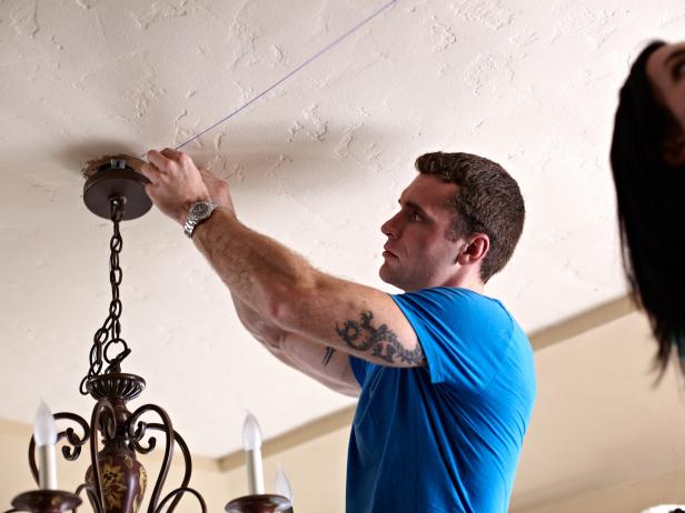 Two people should hold it taut in place, and one person should pull down and release the chalk-covered string to snap a chalky line on the ceiling.
