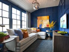 Bathed in blue, the upstairs gathering space offers a spot to relax, watch television, and play games.