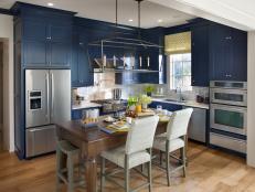 Defined by navy hues, a custom-built island and clever storage, the high-tech kitchen offers space for both food prep and casual dining.