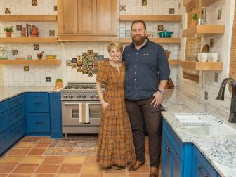 As seen on HGTV’s Hometown, Ben and Erin Napier stand in the newly renovated kitchen of a craftsman-style home in Laurel, MS. The kitchen now features a spanish-inspired tile backsplash, all new floors, beautiful open shelving.