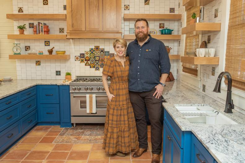 As seen on HGTV’s Hometown, Ben and Erin Napier stand in the newly renovated kitchen of a craftsman-style home in Laurel, MS. The kitchen now features a spanish-inspired tile backsplash, all new floors, beautiful open shelving.