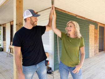 As seen on Fixer to Fabulous Welcome Inn on HGTV, Dave (L) and Jenny (R) Marrs high five on the large outdoor deck that has been completed. The home is located in Rogers, Arkansas.