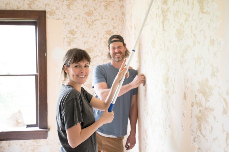 Leanne and Steve ford working on taking off the wallpaper in the vintage victorian home they are renovating together as seen on Restored by the Ford