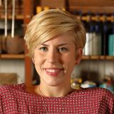 As seen on Home Town, Erin Napier (C) in their workshop located in Laurel, MS. Erin and Ben visit estate sales and flea markets looking for antique cotton flags to carry in their shop, the Laurel Mercantile Co. The flag in this photo hangs in their shop as a reminder of why American-made craftsmanship still matters.(workshop, portrait)