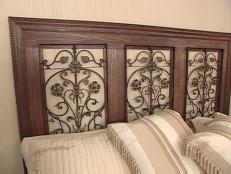 Create a custom headboard with lumber and wrought iron panels.