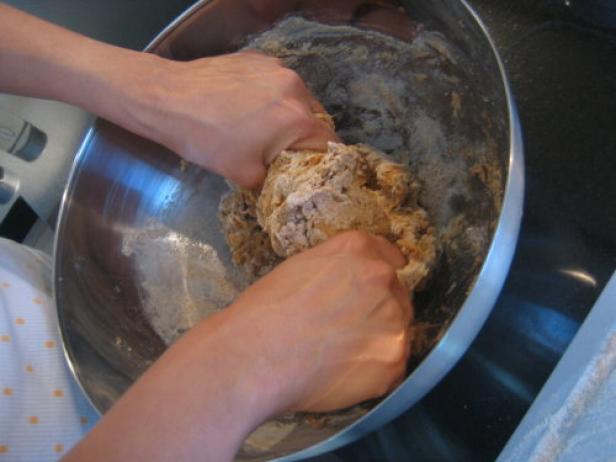 Hands Kneading Dough in Silver Bowl