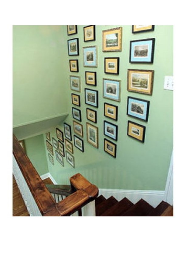 Green Wall Covered in Picture Frames Leading Down Stairs