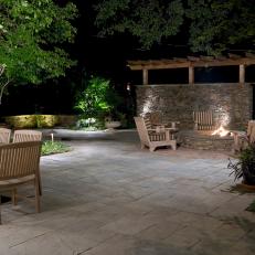 Stone Patio With Round Fire Pit And Striped Outdoor Chairs