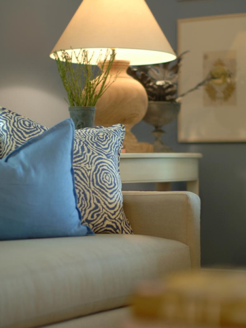 Upholstered Chair With Natural Wood Lamp and Blue Patterned Pillows