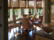 Green Breakfast Nook With Round Wood Dining Table and Rattan Chairs