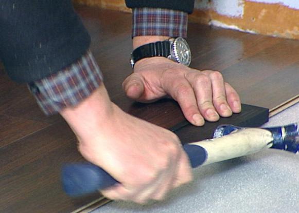 Man Using Mallet on Flooring