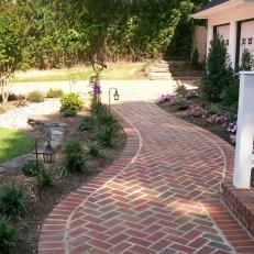 Curved Brick Walkway With Landscaped Garden Beds