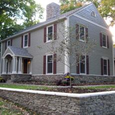 Gray Colonial Home with Dark Red Shutters
