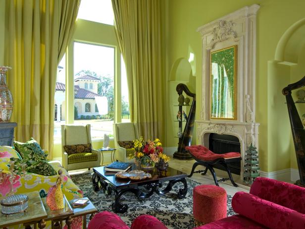 Green Living Room With Draperies, Ornate Fireplace and Fuchsia Chairs