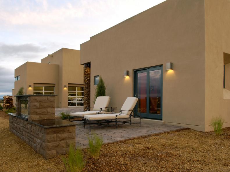 Southwestern Stucco Home With Stone Patio and Two Lounge Chairs