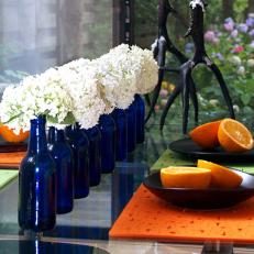 Glass Dining Table With Colbalt-Blue Bottle Centerpiece 