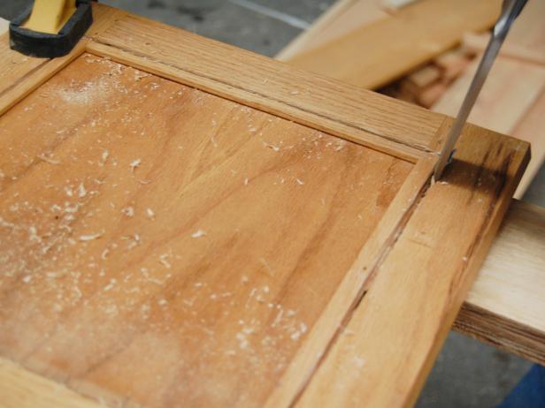 Chiseling wood free from a cut cabinet door frame. 
