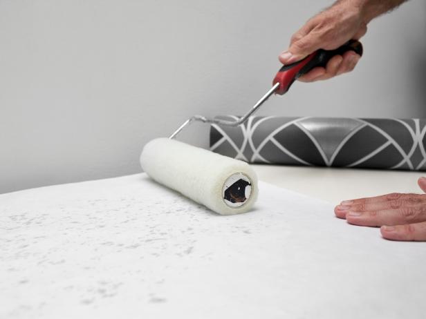Man applying paste to wallpaper.