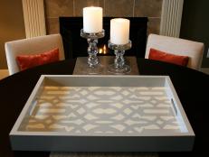 A DIY stenciled tray on a black table.