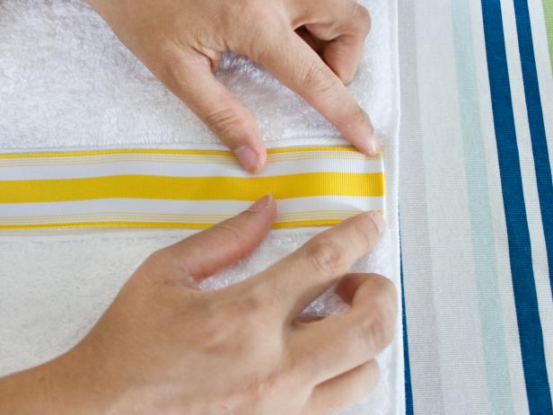 Pressing White and Yellow Striped Ribbon Onto Towel