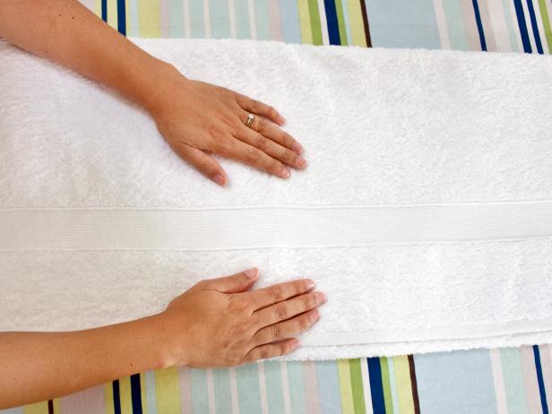 Smoothing Out White Bath Towel With Both Hands