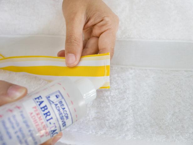 Applying Glue to White and Yellow Striped Ribbon