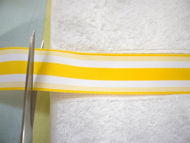 Scissors Cutting Yellow and White Striped Ribbon