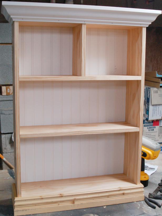 After the base molding is attached, it will extend beyond bottom edge of the unfinished shelf.