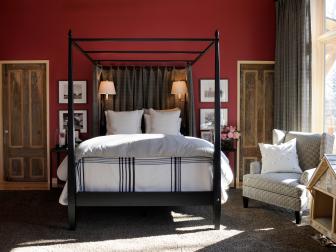 Red Bedroom With Black Bed Frame, Neutral Chair and Brown Walnut Doors