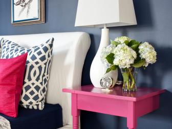Blue Bedroom With Half Pink Nightstand, White Lamp and White Flowers
