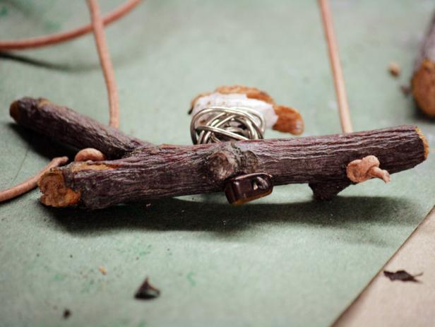 Knot the leather cording under the branch to secure the ends.