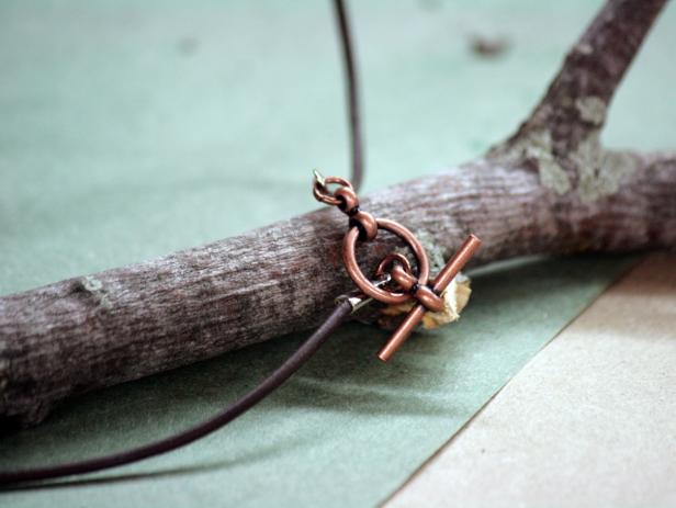 After knotting the necklace cord under the branch, add closing clasps of your choice.