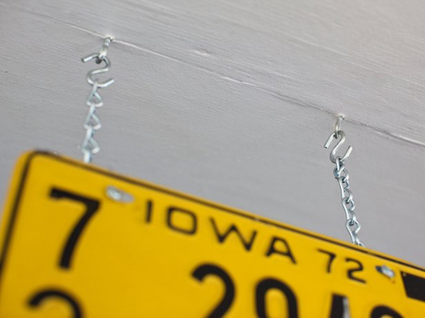 Yellow License Plate Hanging From Ceiling on Metal Chains