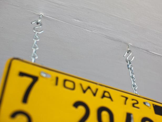 Yellow License Plate Hanging From Ceiling on Metal Chains