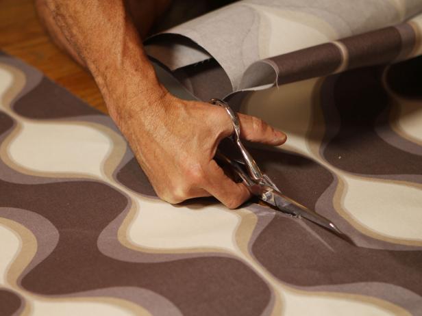 Cutting Gray Retro Patterned Fabric With Scissors