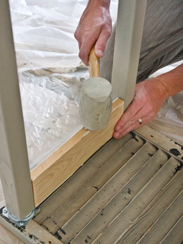 Hands Using Rubber Mallet to Force Lumber Between Table Legs