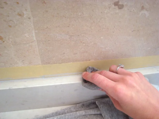 Use a straight blade to remove any large pieces of excess caulk. A rag with acetone will help further smooth the seams and clean up any residue from the caulk.