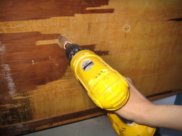 Yellow Drill Cuts Holes on Wood Panel
