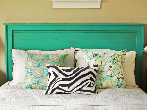 Green Wooden Headboard Adorned With Decorative Pillows