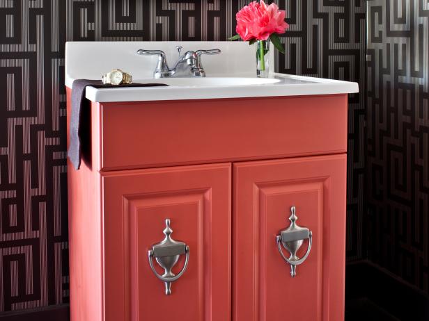 Pink Vanity With Silver Door Knocker Hardware in Wallpapered Bathroom
