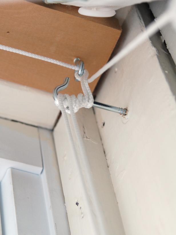 Hold header board tight to window trim and insert a screw in each pilot hole. Tighten a screw hook in side of window frame to wrap excess cord around when blind is raised.