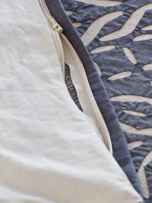 Turn duvet cover inside out, insert a duvet through the zippered opening and close it up.