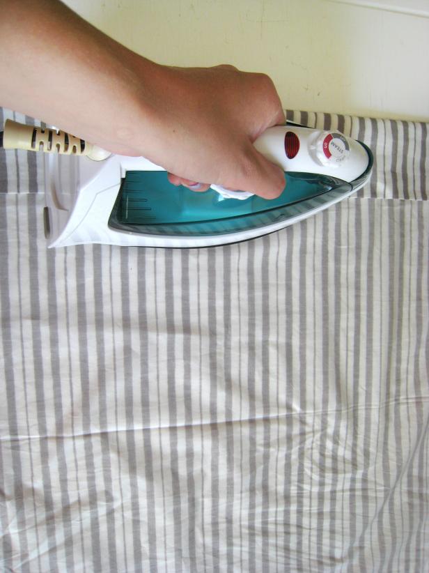 Person Ironing Striped Fabric