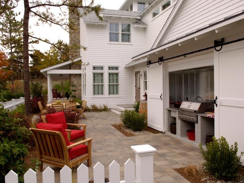 Patio With Grill, Sliding White Doors & Wood Chairs With Red Cushions