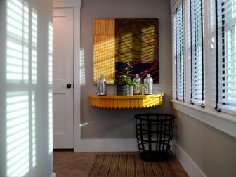 Yellow Table With Yellow & Green Painting and Black Basket in Hallway