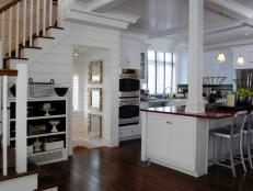 White Kitchen With Wood Paneling, Red Countertop and Support Column