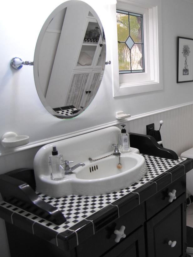 Black vanity with black and white tile in a small check pattern. 
