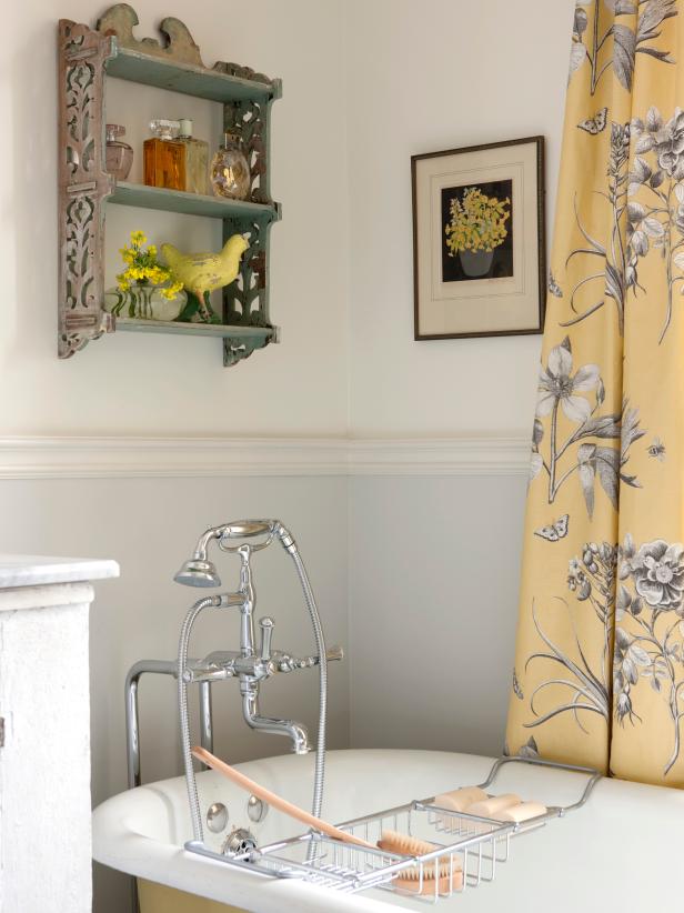 A gorgeous French country style bathroom with design by Sarah Richardson features yellow toile curtains and vintage clawfoot tub. #sarahrichardson #bathroomdesign #frenchcountry
