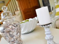 Seashell Filled Vase and White Pillar Candle on White Table