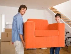 A Couple Carrying an Orange Chair